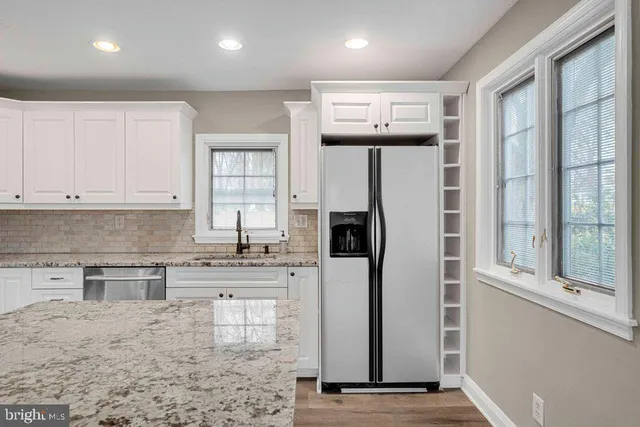 a kitchen with stainless steel appliances granite countertop a refrigerator and a stove top oven