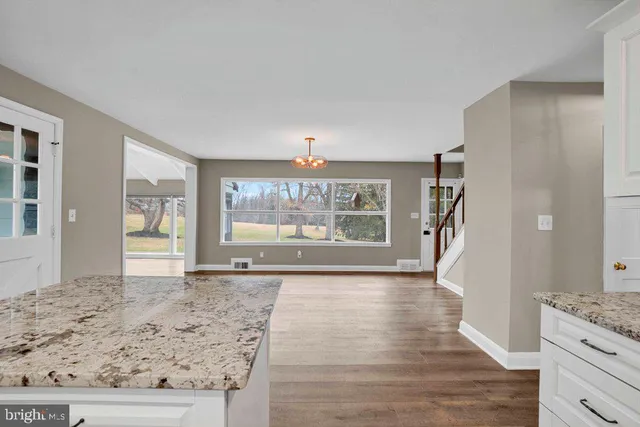a view of a hallway with wooden floor and chandelier