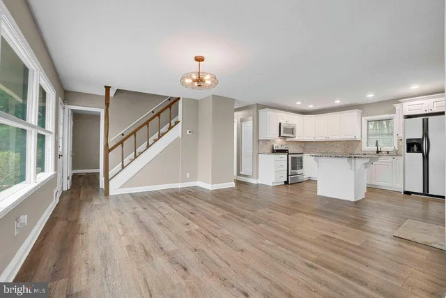 a view of a kitchen with wooden floor and electronic appliances