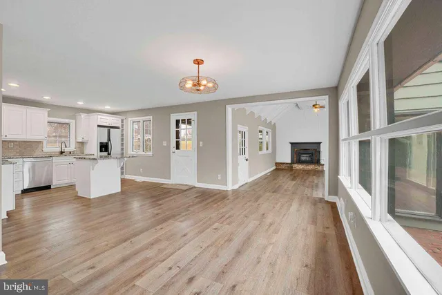 a view of a kitchen with wooden floor and windows