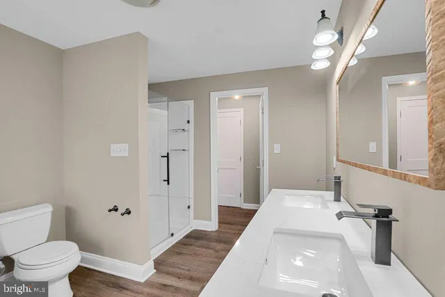 a spacious bathroom with a toilet a sink and mirror