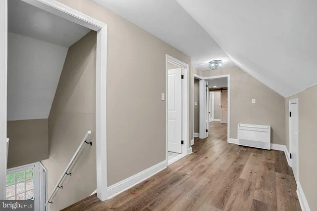 a view of a hallway with wooden floor and staircase