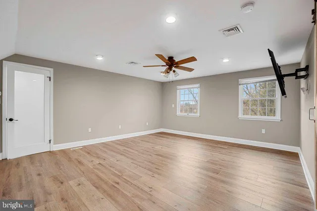 a view of a hallway with wooden floor and closet