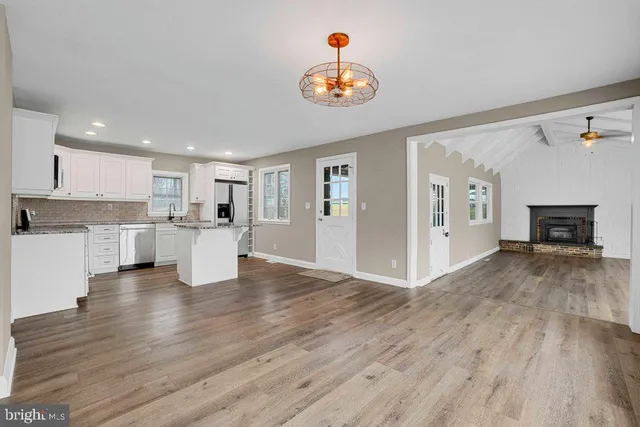 a view of a kitchen with a sink a refrigerator and a stove top oven