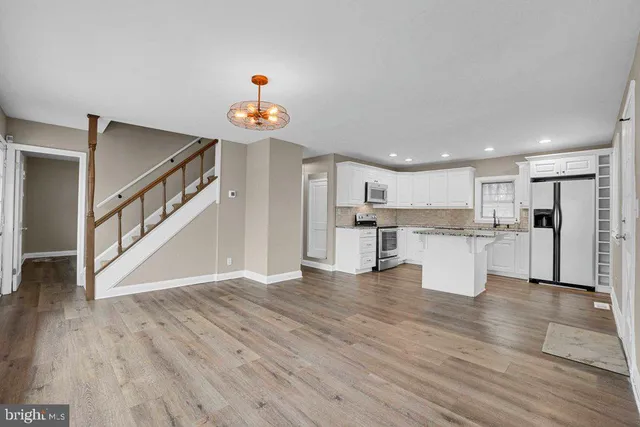 a view of kitchen with wooden floor and electronic appliances