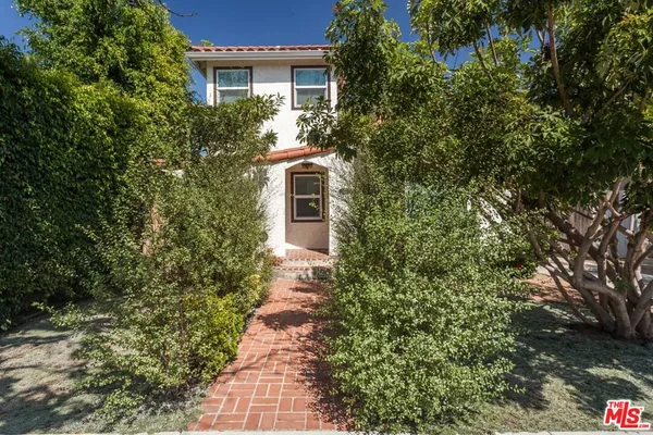 a front view of a house with a yard and fountain