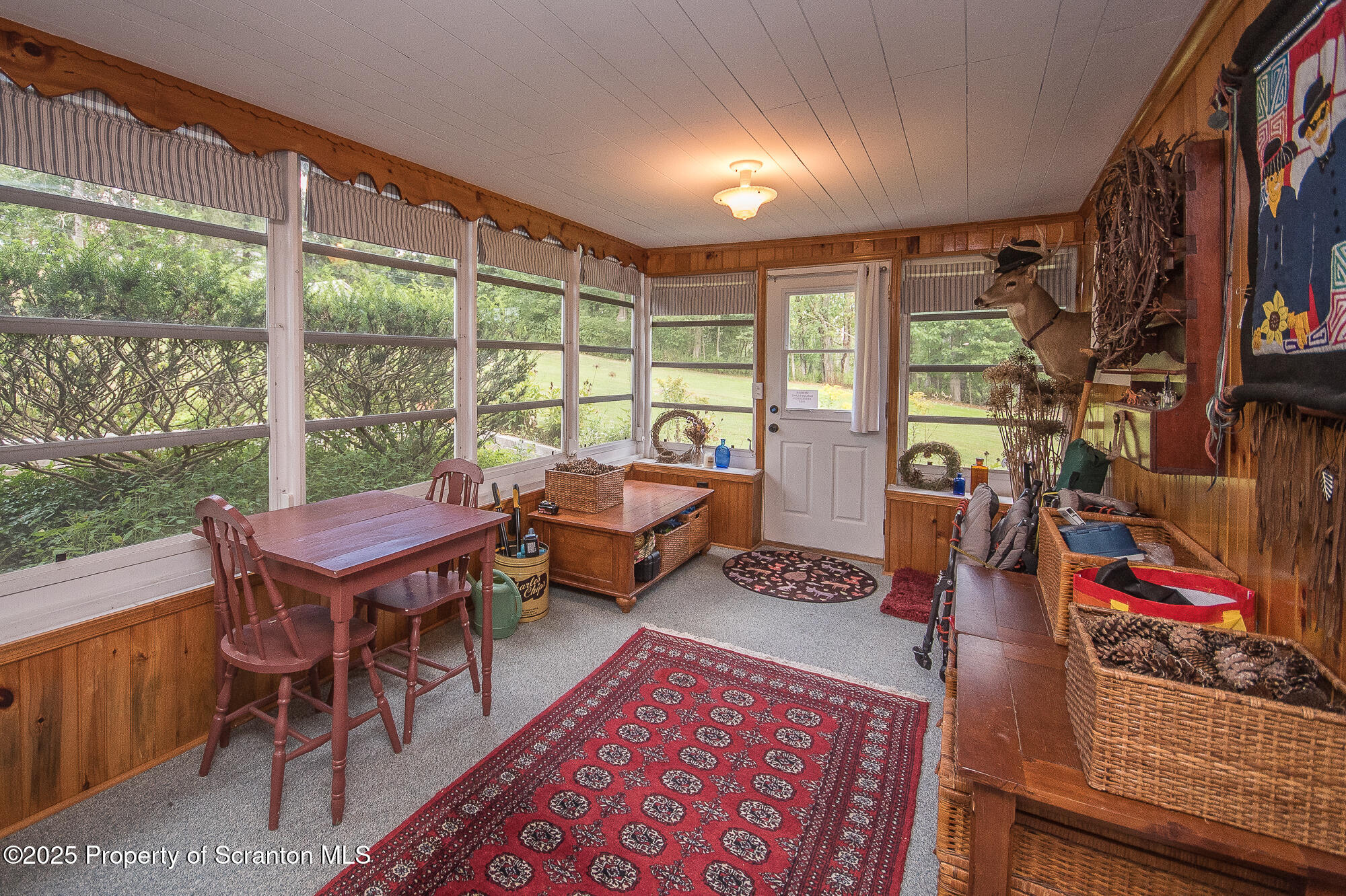 260 Baylors Lake Road Fleetville, PA 18420 - Photo 22 of 69 a living room with furniture a rug and a floor to ceiling window