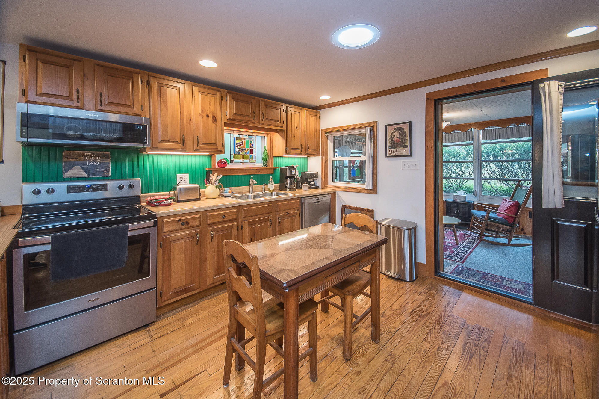 260 Baylors Lake Road Fleetville, PA 18420 - Photo 28 of 69 a kitchen with stainless steel appliances granite countertop wooden cabinets a stove top oven a sink and dishwasher a dining table with wooden floor