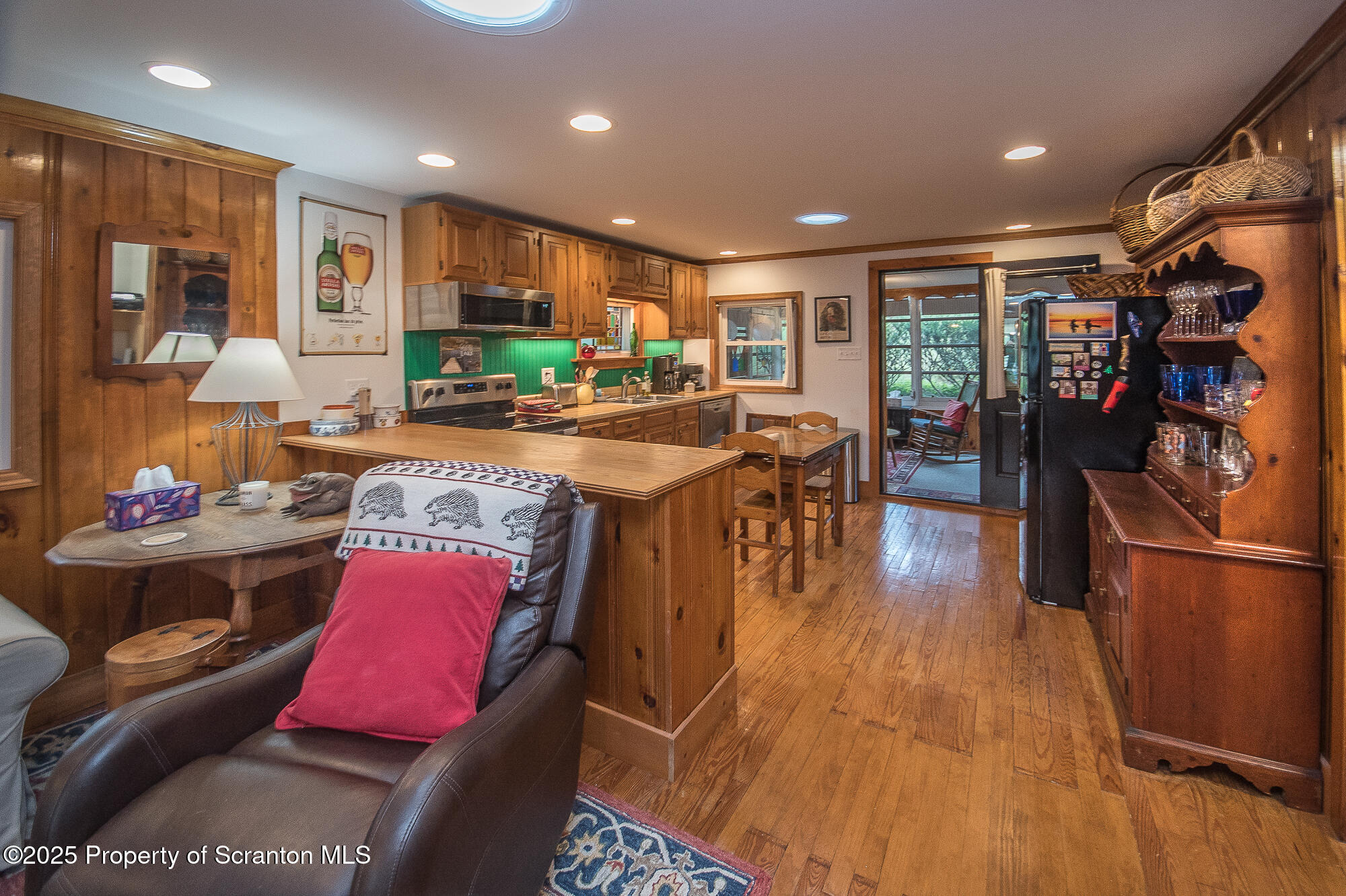 260 Baylors Lake Road Fleetville, PA 18420 - Photo 38 of 69 a kitchen with stainless steel appliances granite countertop a refrigerator a stove top oven a dining table and chairs with wooden floor