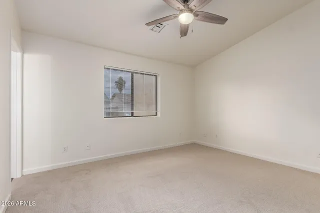 an empty room with a ceiling fan and a window