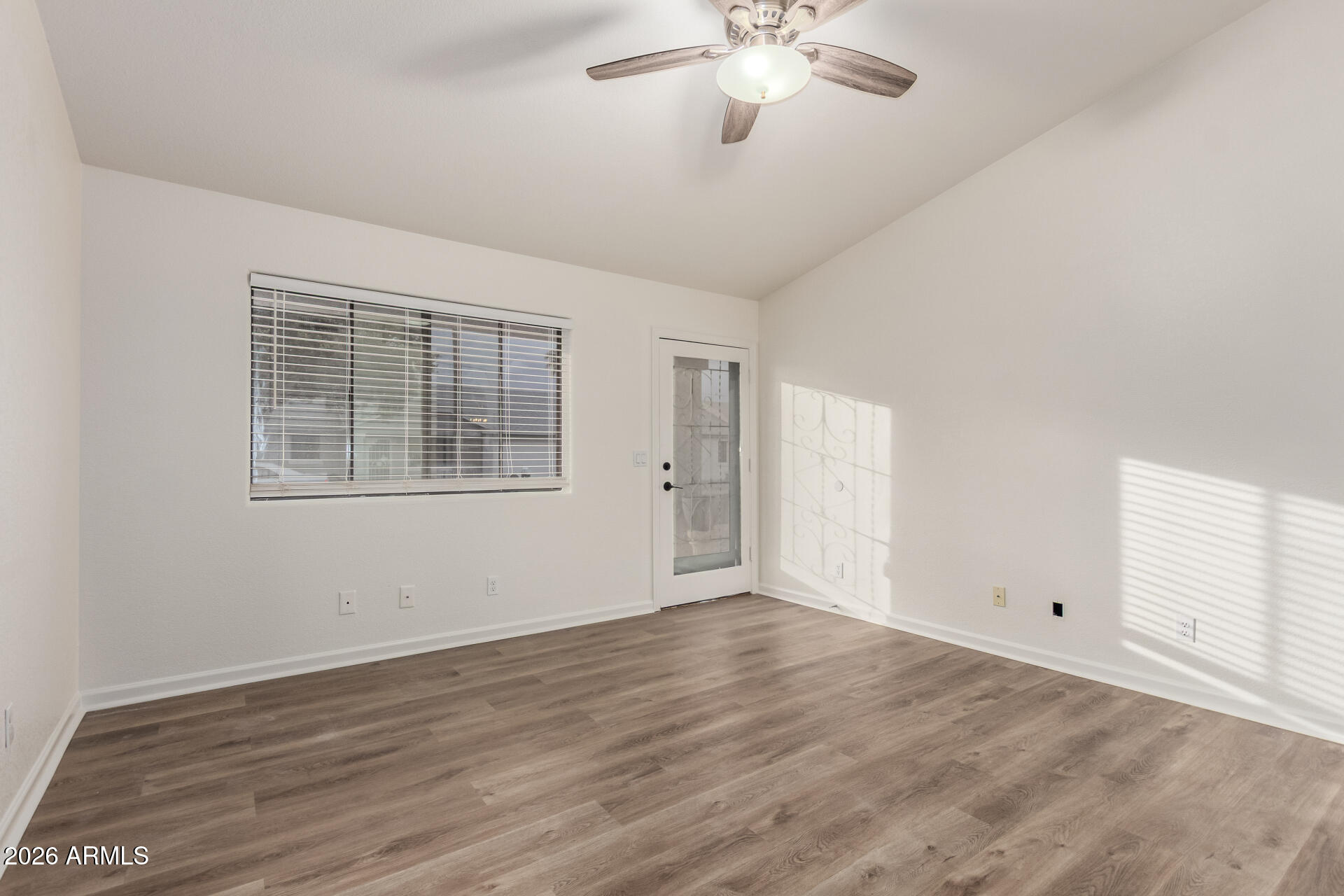 335 South Stardust Lane Apache Junction, AZ 85120 - Photo 10 of 31 a view of an empty room with wooden floor and a window