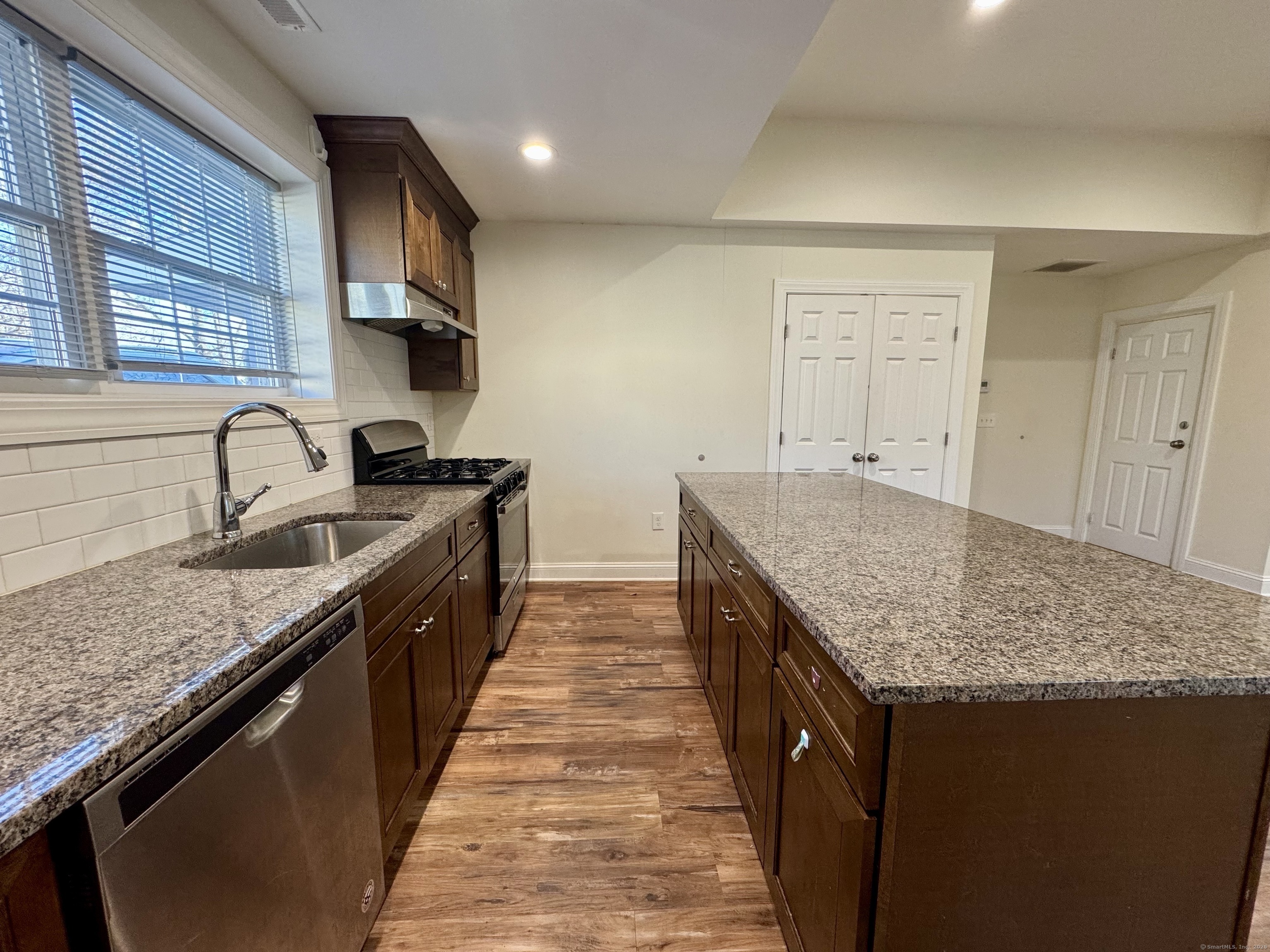 950 Lindley Street Bridgeport, CT 06606 - Photo 4 of 14 a kitchen with granite countertop kitchen island a sink dishwasher stove and cabinets