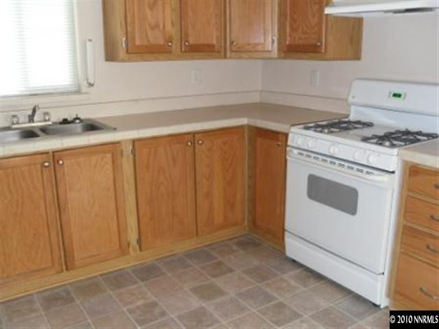 357 Rue De Lane Sparks, NV 89434 - Photo 4 of 7 a kitchen with granite countertop white cabinets and white appliances