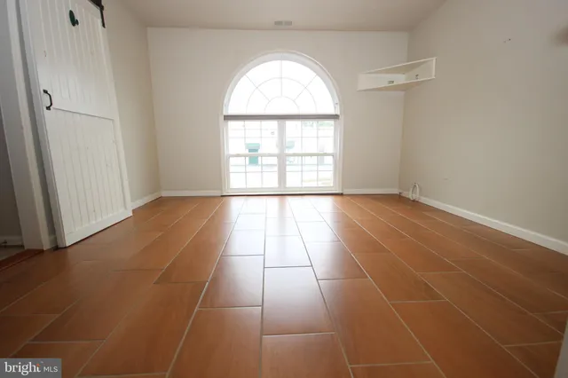 an empty room with white walls and a window