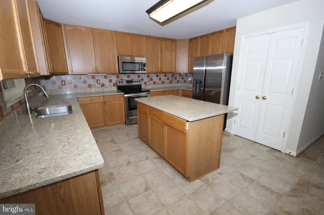 a kitchen with stainless steel appliances granite countertop a stove a refrigerator a sink a oven and dishwasher