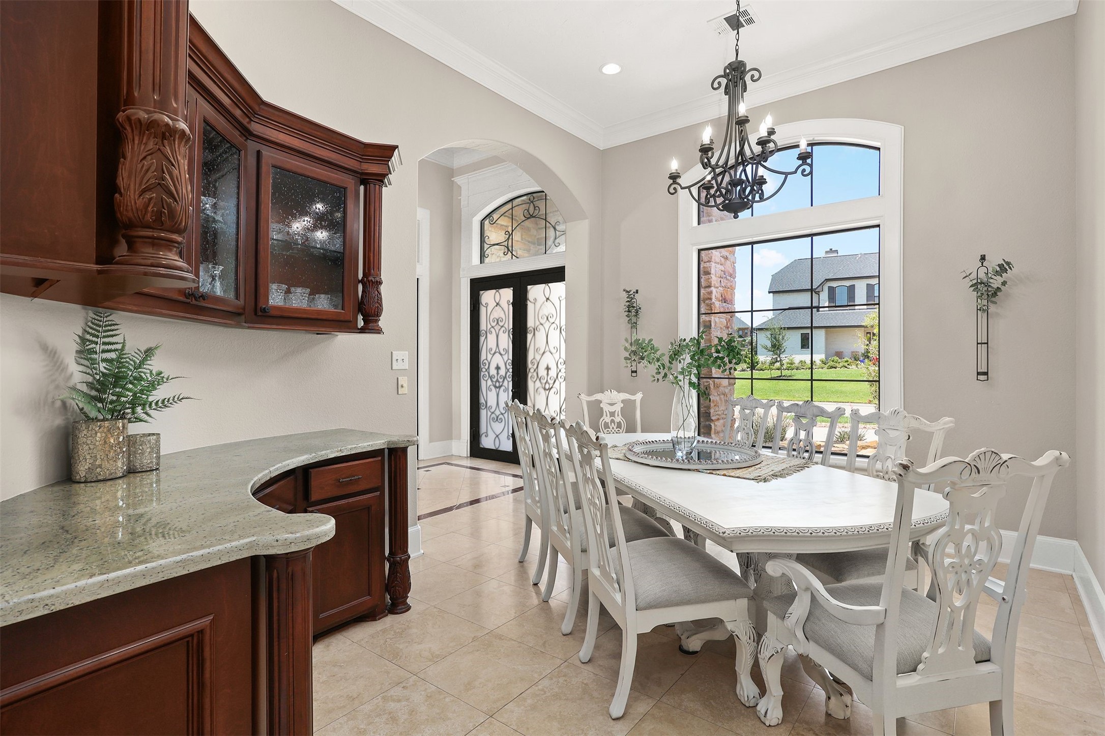 10896 Decatur Street Willis, TX 77318 - Photo 16 of 50 This sophisticated dining area features high ceilings, light-colored walls, and decorative moldings, with a large window overlooking the front yard, a stunning chandelier, and an ornate wooden table with matching chairs, creating an elegant and inviting atmosphere.