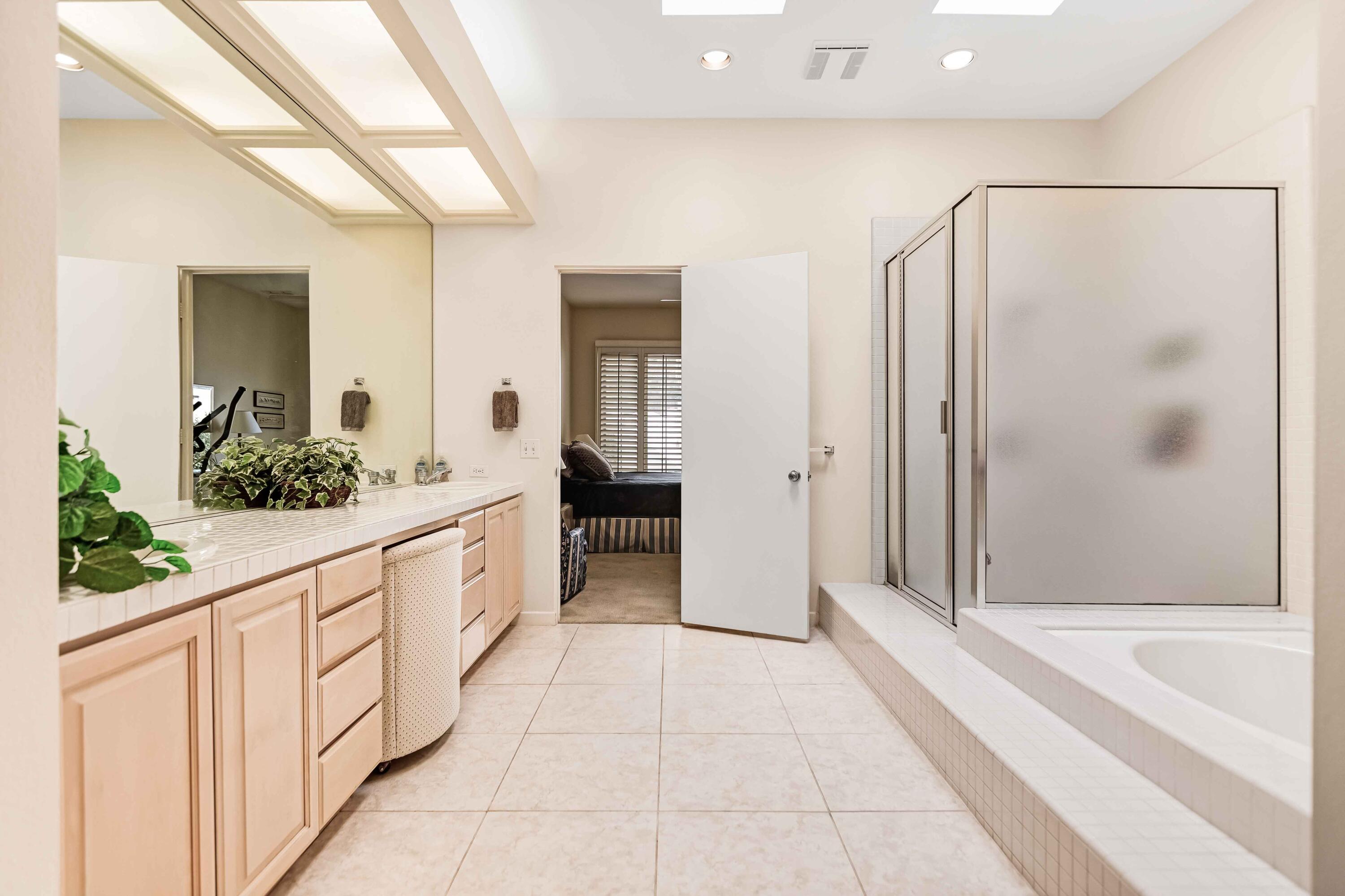 57600 Interlachen La Quinta, CA 92253 - Photo 31 of 87 a large white bathroom with a granite countertop tub a mirror and a shower