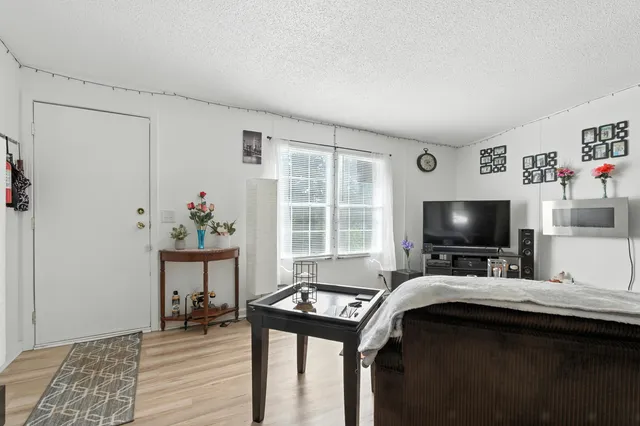 a living room with dining table and a large window
