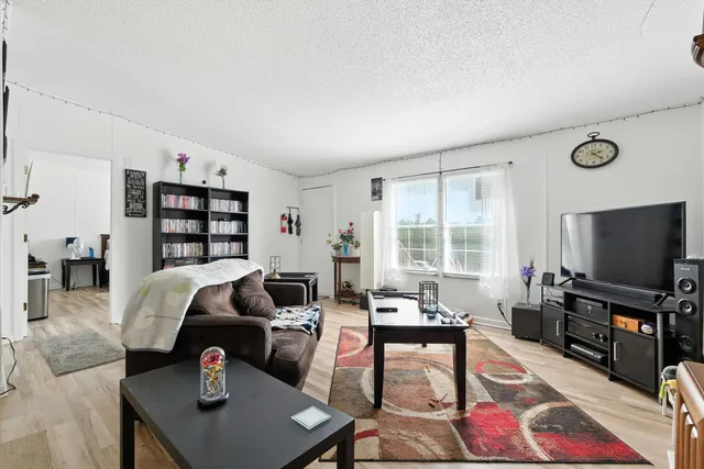 a kitchen with stainless steel appliances granite countertop a stove a sink dishwasher and a refrigerator with white cabinets