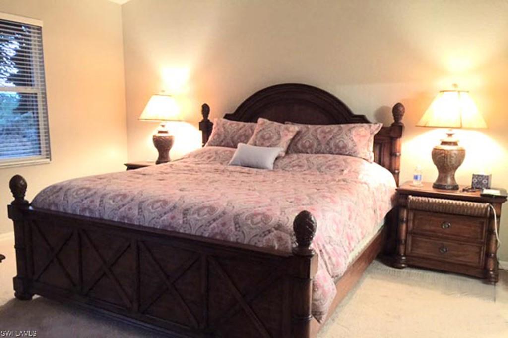 8365 Whisper Trace Way, Unit L203 Naples, FL 34114 - Photo 12 of 24 a bedroom with a bed and a lamp on dresser