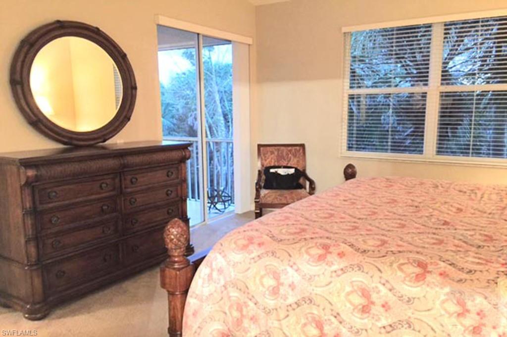 8365 Whisper Trace Way, Unit L203 Naples, FL 34114 - Photo 13 of 24 a bed room with a bed and a mirror