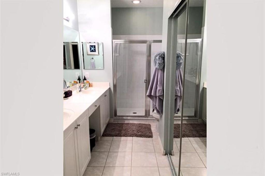 8365 Whisper Trace Way, Unit L203 Naples, FL 34114 - Photo 14 of 24 a bathroom with a double vanity sink and a mirror