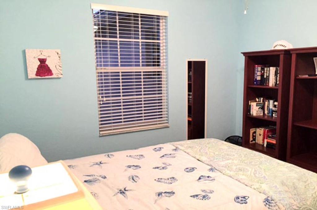 8365 Whisper Trace Way, Unit L203 Naples, FL 34114 - Photo 16 of 24 a bedroom with a bed and a book shelf