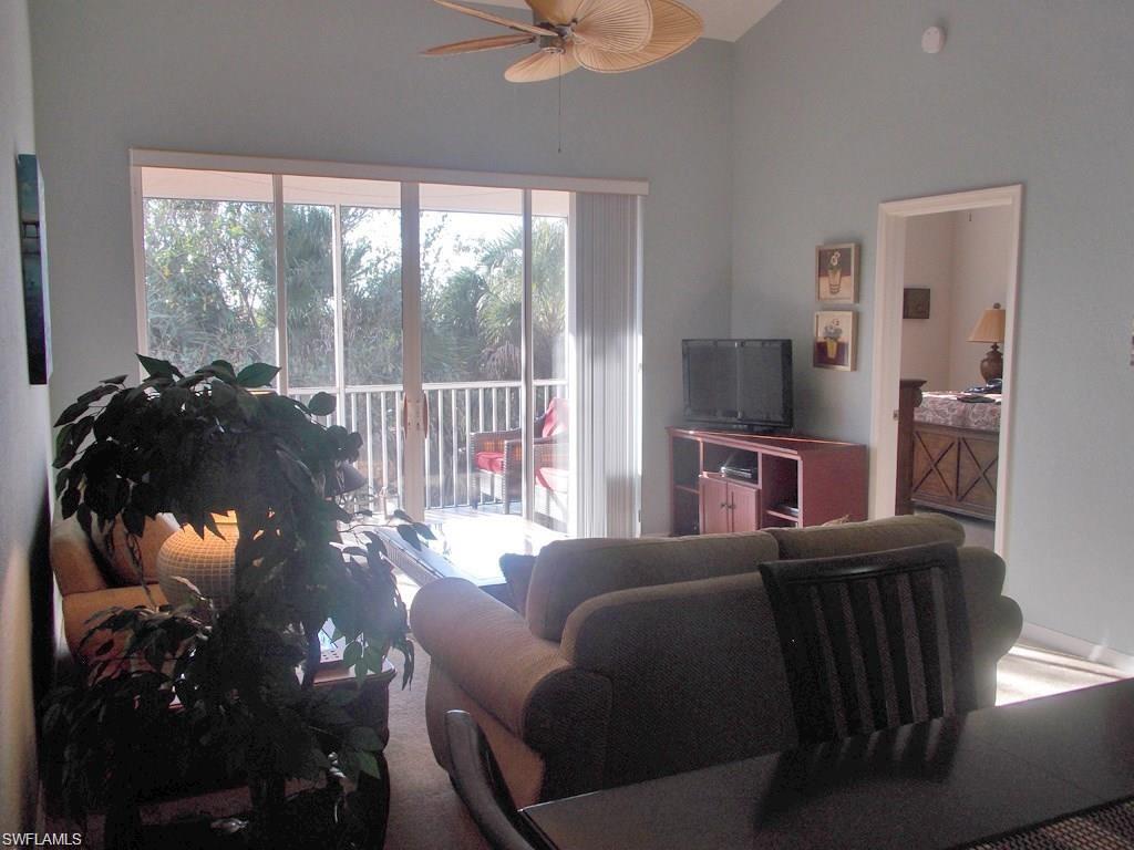 8365 Whisper Trace Way, Unit L203 Naples, FL 34114 - Photo 3 of 24 a living room with furniture and a floor to ceiling window
