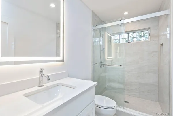 a bathroom with a sink a toilet and shower