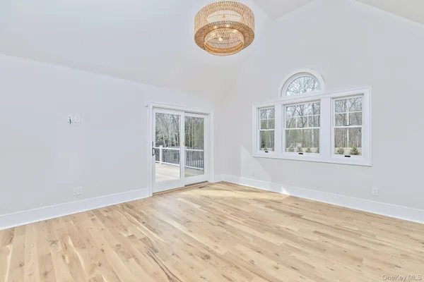 a view of empty room with wooden floor and window