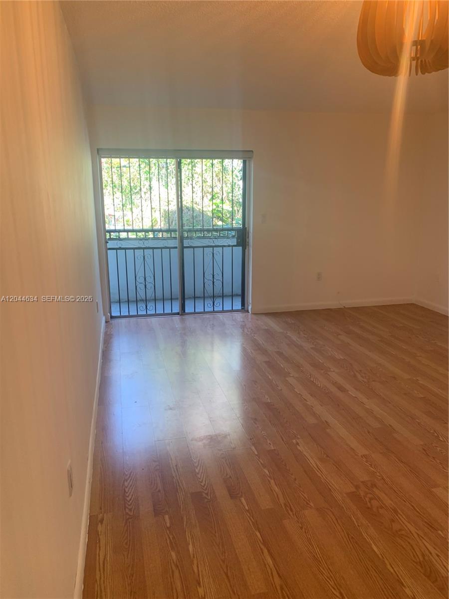 2460 Southwest 18th Avenue, Unit 1205 Miami, FL 33133 - Photo 5 of 21 wooden floor in an empty room with a window