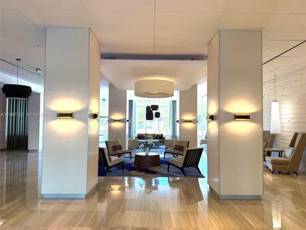 a living room with a large window and a chandelier