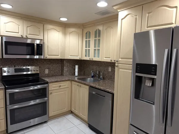 a kitchen with kitchen island a counter space and a view of living room