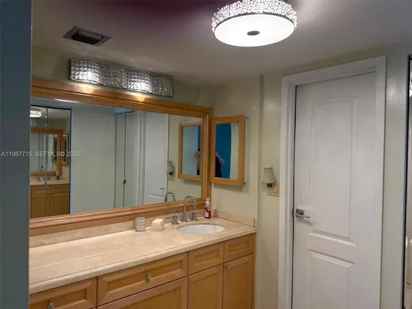 a bathroom with a sink vanity granite and a mirror