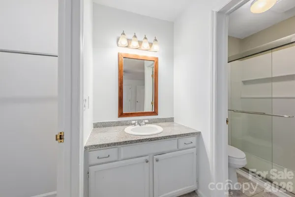 a bathroom with a granite countertop sink toilet and shower