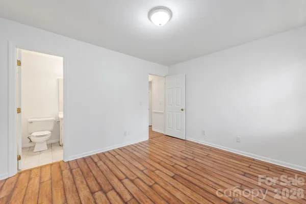 a view of a room with wooden floor and a toilet