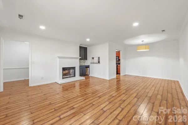 a view of empty room with wooden floor and fireplace
