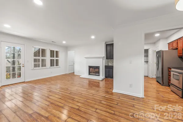 a view of empty room with wooden floor and fireplace