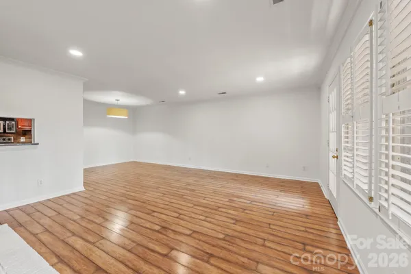 a view of empty room with wooden floor