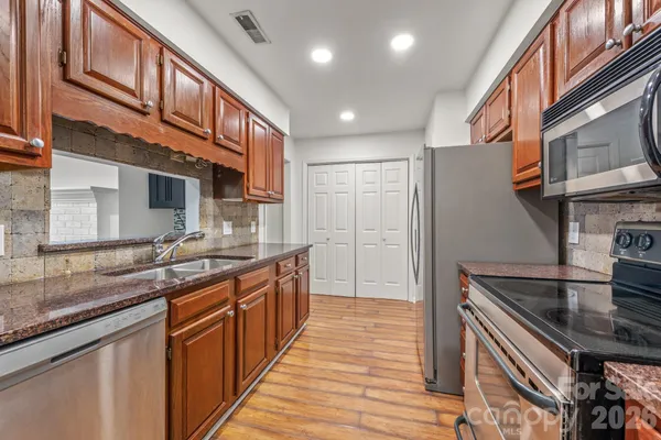 a kitchen with stainless steel appliances granite countertop a sink and a stove