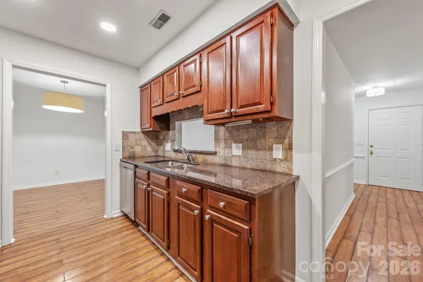 a kitchen with stainless steel appliances granite countertop a sink stove and cabinets