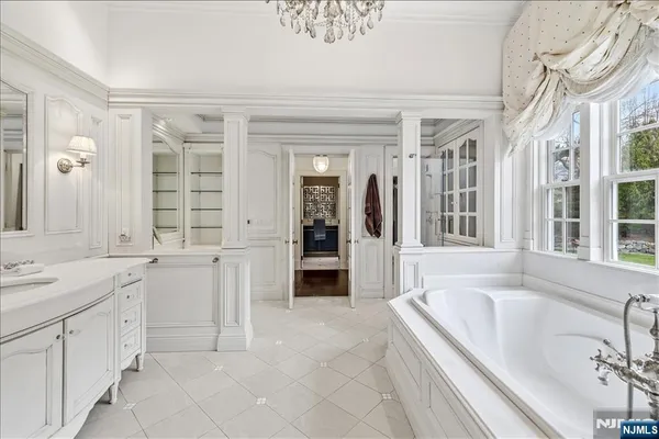 a spacious en suite bathroom with a granite countertop sink mirror and bathtub