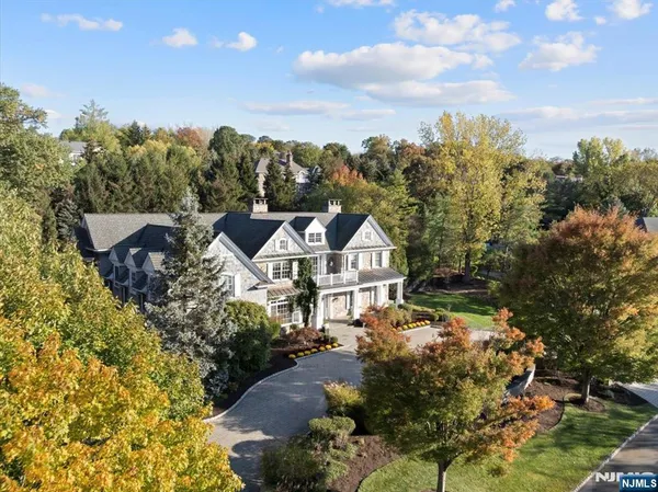 a view of a house with a big yard and large tree
