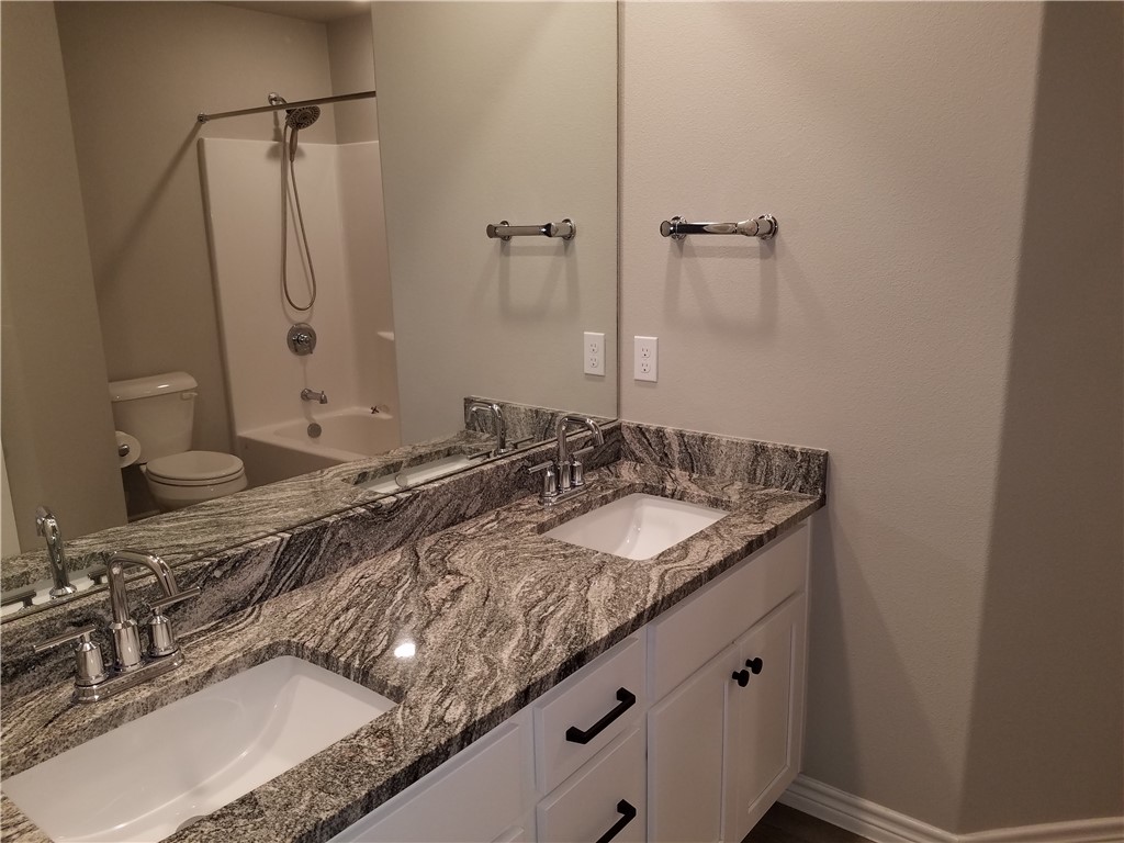 7202 Bryson Way Corpus Christi, TX 78414 - Photo 11 of 12 a bathroom with a granite countertop sink and a mirror