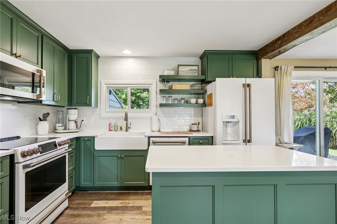 6147 Stone Road Medina, OH 44256 - Photo 17 of 40 Kitchen featuring green cabinets, white appliances, decorative backsplash, dark wood-style floors, and recessed lighting