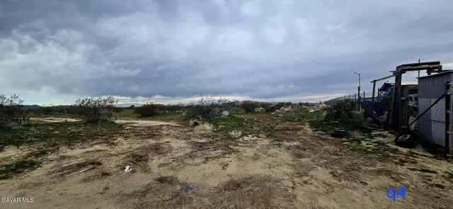 a view of a yard with wooden fence