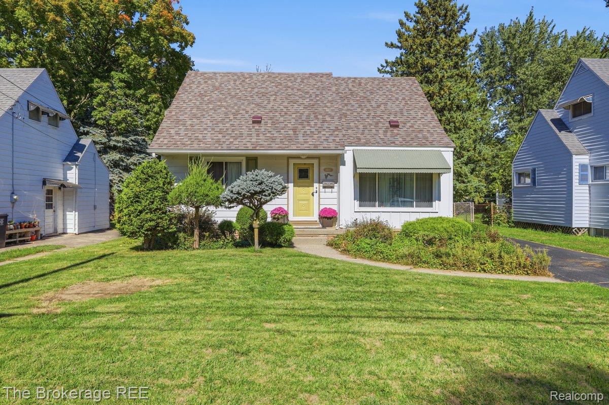 613 East Atherton Road Flint, MI 48507 - Photo 1 of 42 Siding exterior with a gabled roof, front entrance with a yellow door, and a front window with an awning