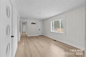 a view of a livingroom with wooden floor and a window