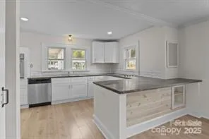 a large kitchen with stainless steel appliances kitchen island granite countertop a stove a sink and a microwave