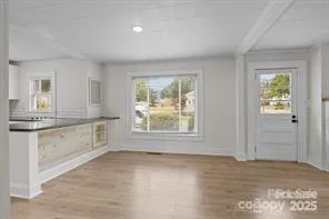 a view of an empty room with a window and fireplace